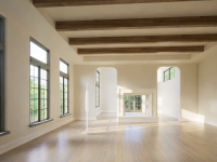Sunlit interior with exposed wood ceiling beams, arched openings, and floor-to-ceiling windows, designed by Ballard+Mensua Architecture to highlight natural light and spatial flow.