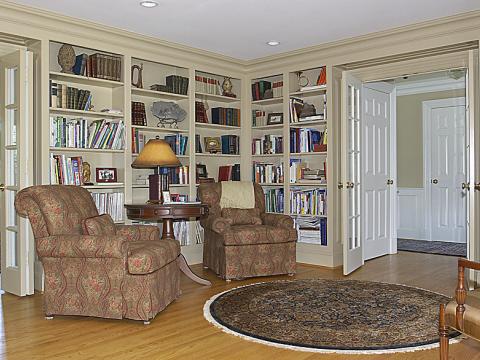 Small library with wood built-ins and comfortable settees