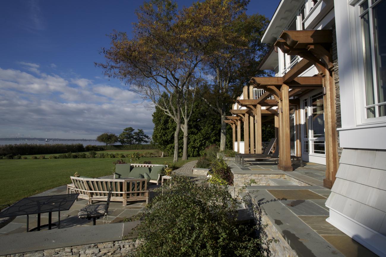 Carr project - nautical New England waterfront home - side patio view in rear